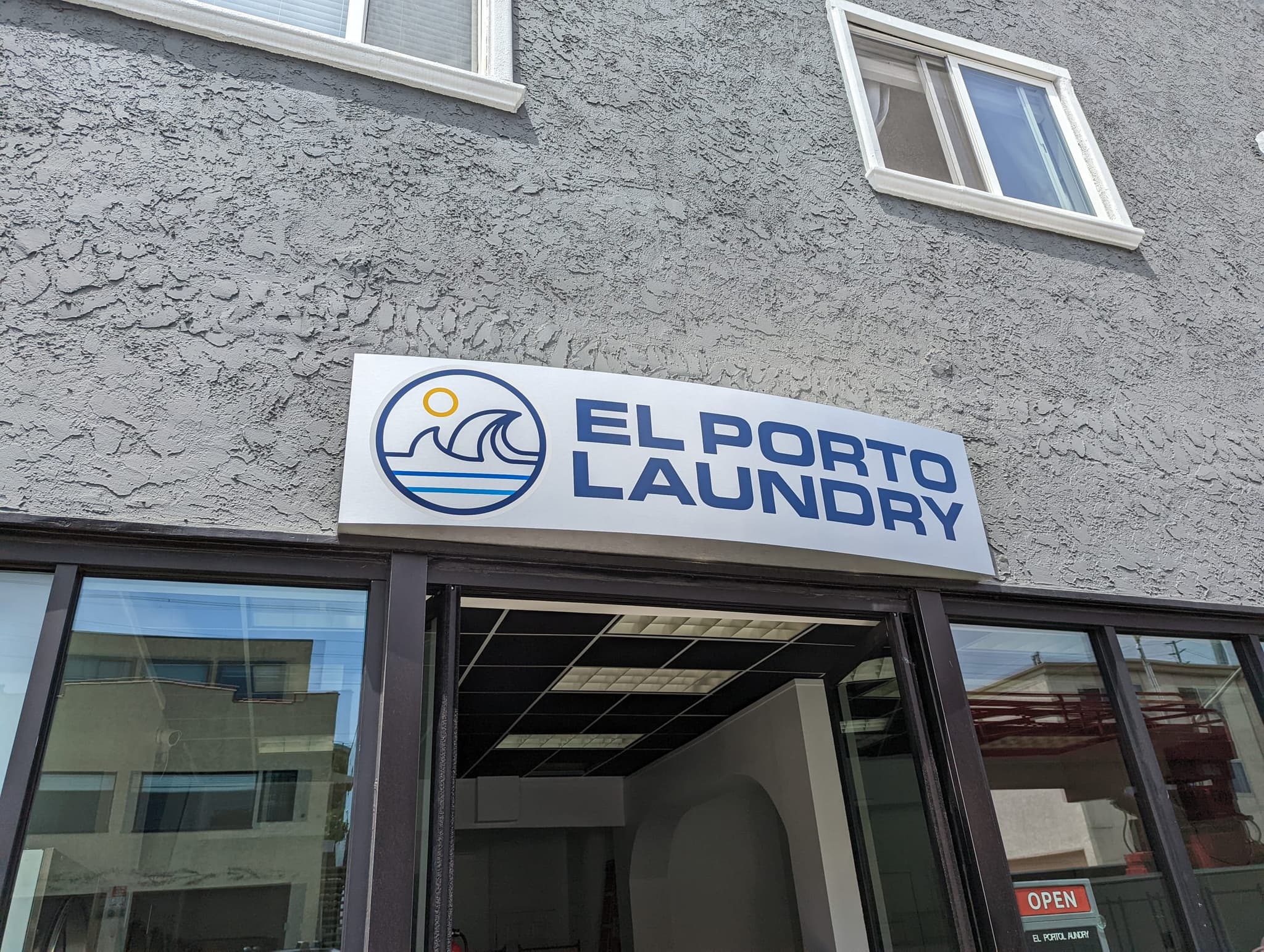 El Porto Laundry exterior sign close-up showing logo and name