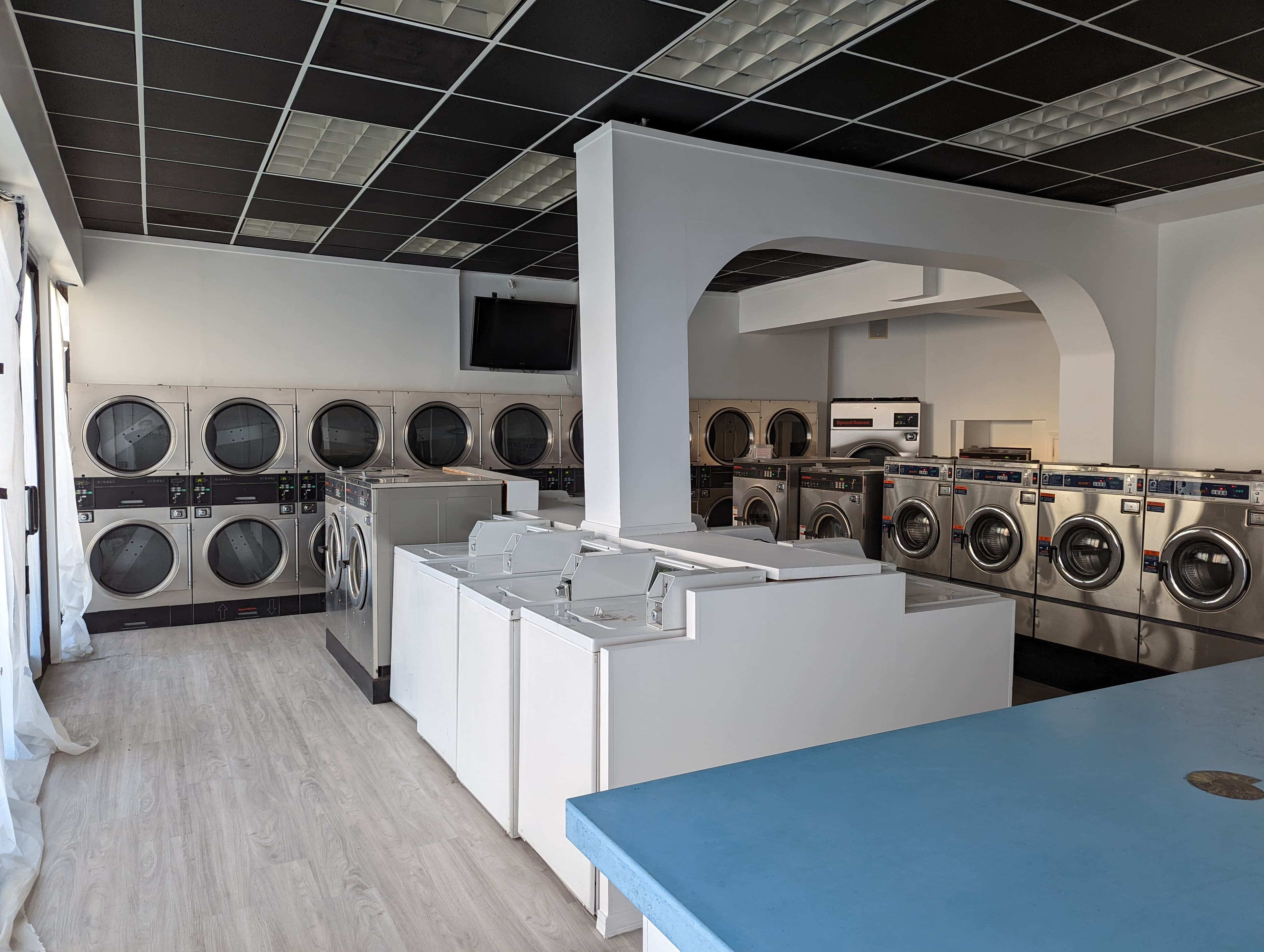 Interior view of El Porto Laundry's renovated self-service laundromat with high-efficiency machines